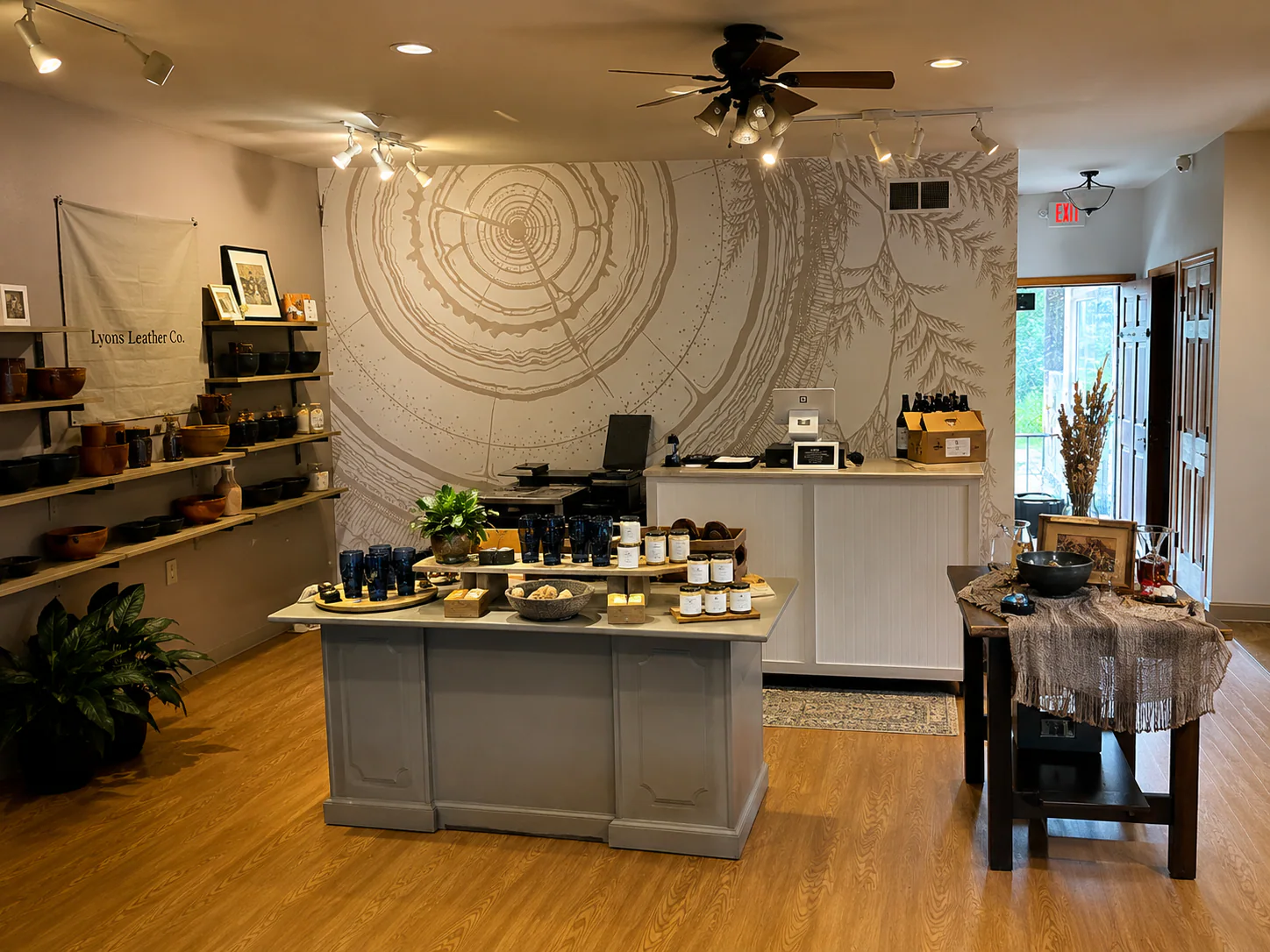 Wide room view showing the cedar mural behind display tables and shelving