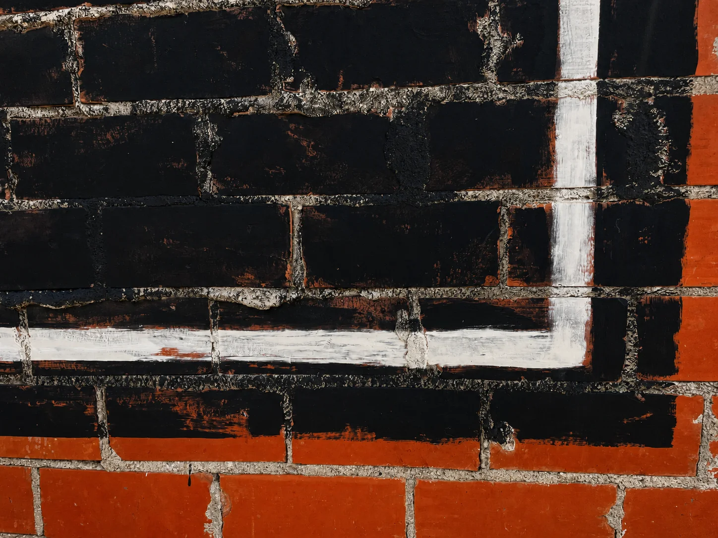 Close detail of crisp white hand-painted border lines over textured black brick