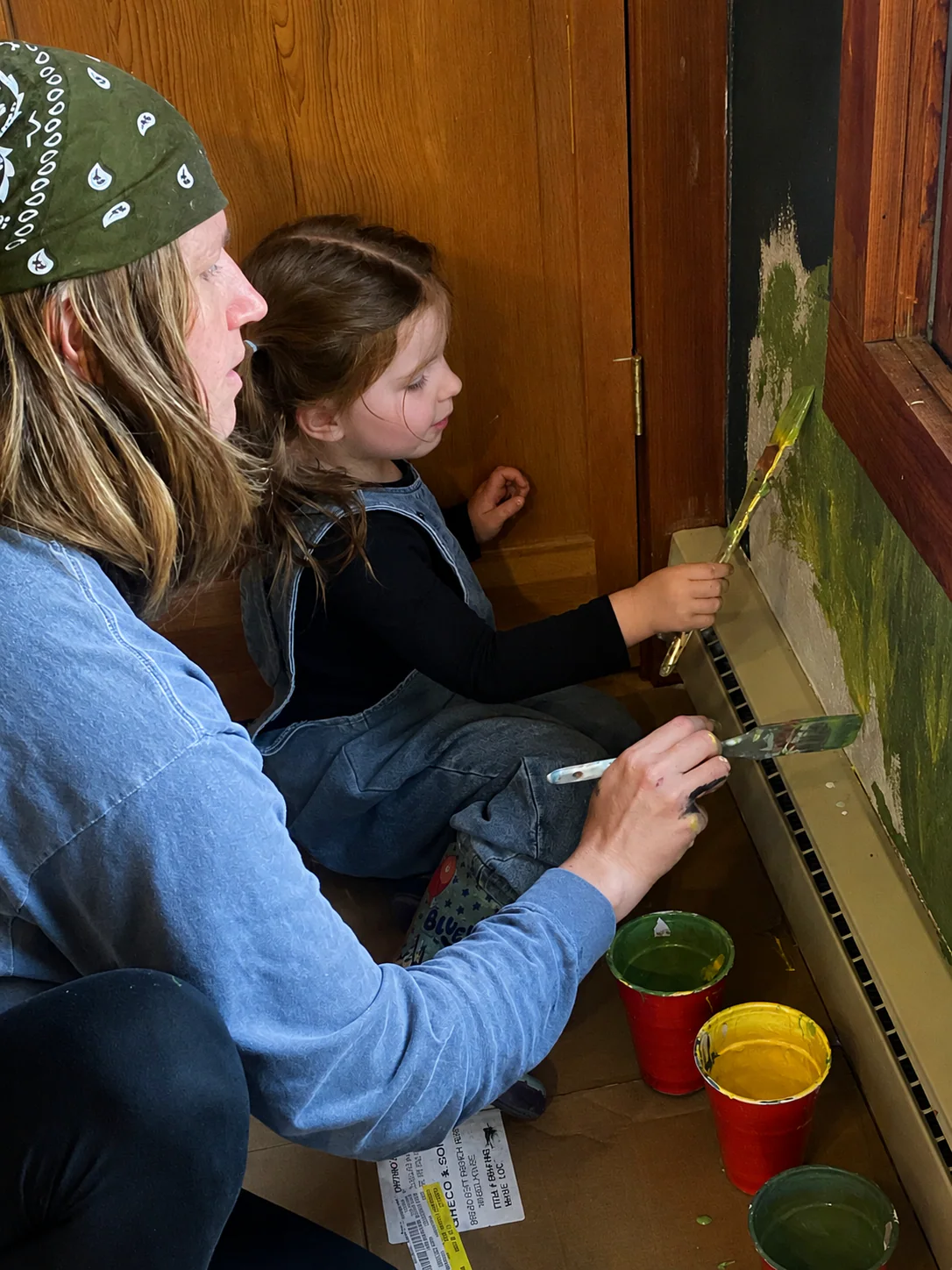 Erin Larwick and Sagan painting details on The Scenic Route mural