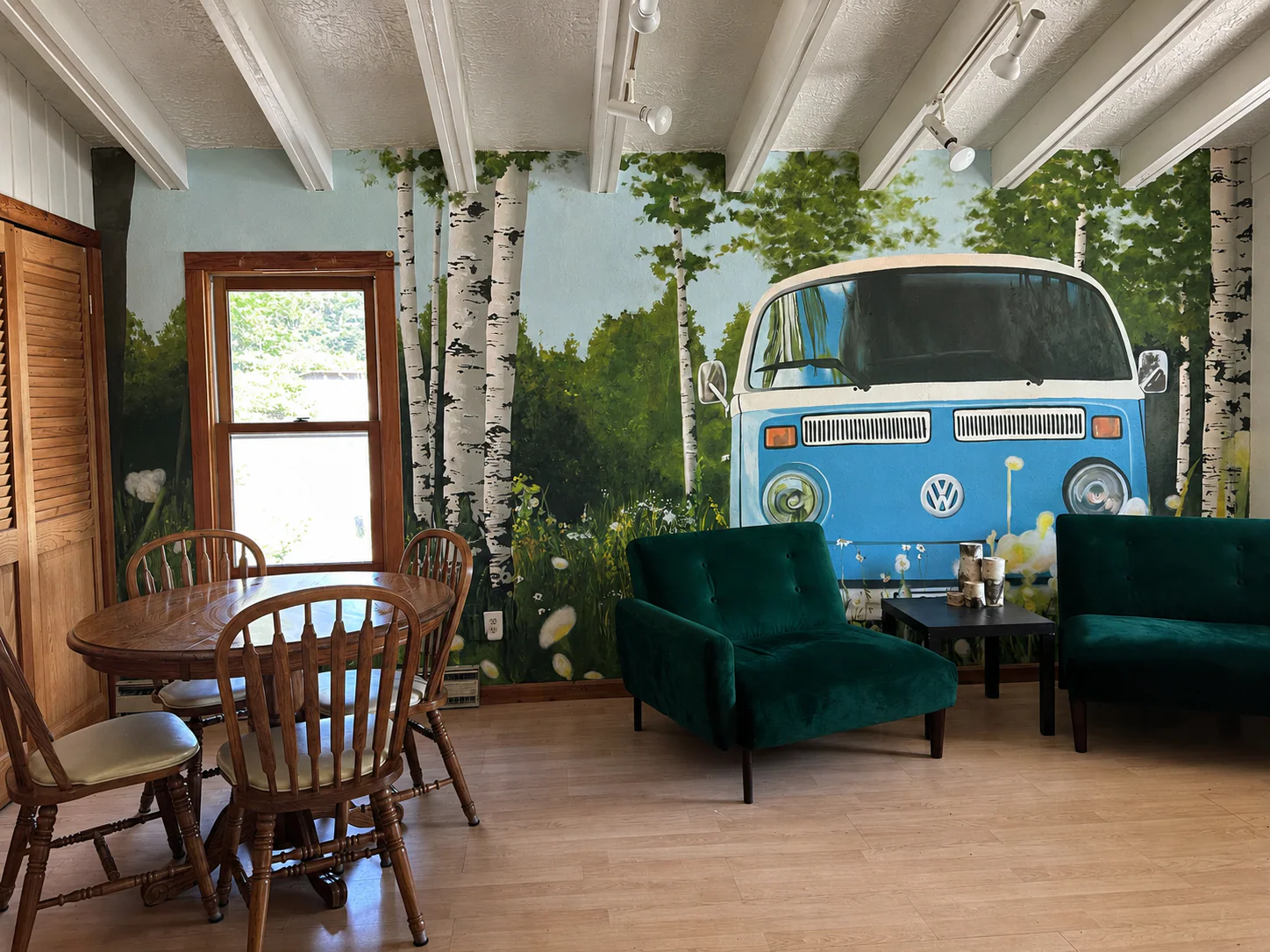 Furnished Backroads Deli dining room set against a mural of a blue Volkswagen bus in a birch forest