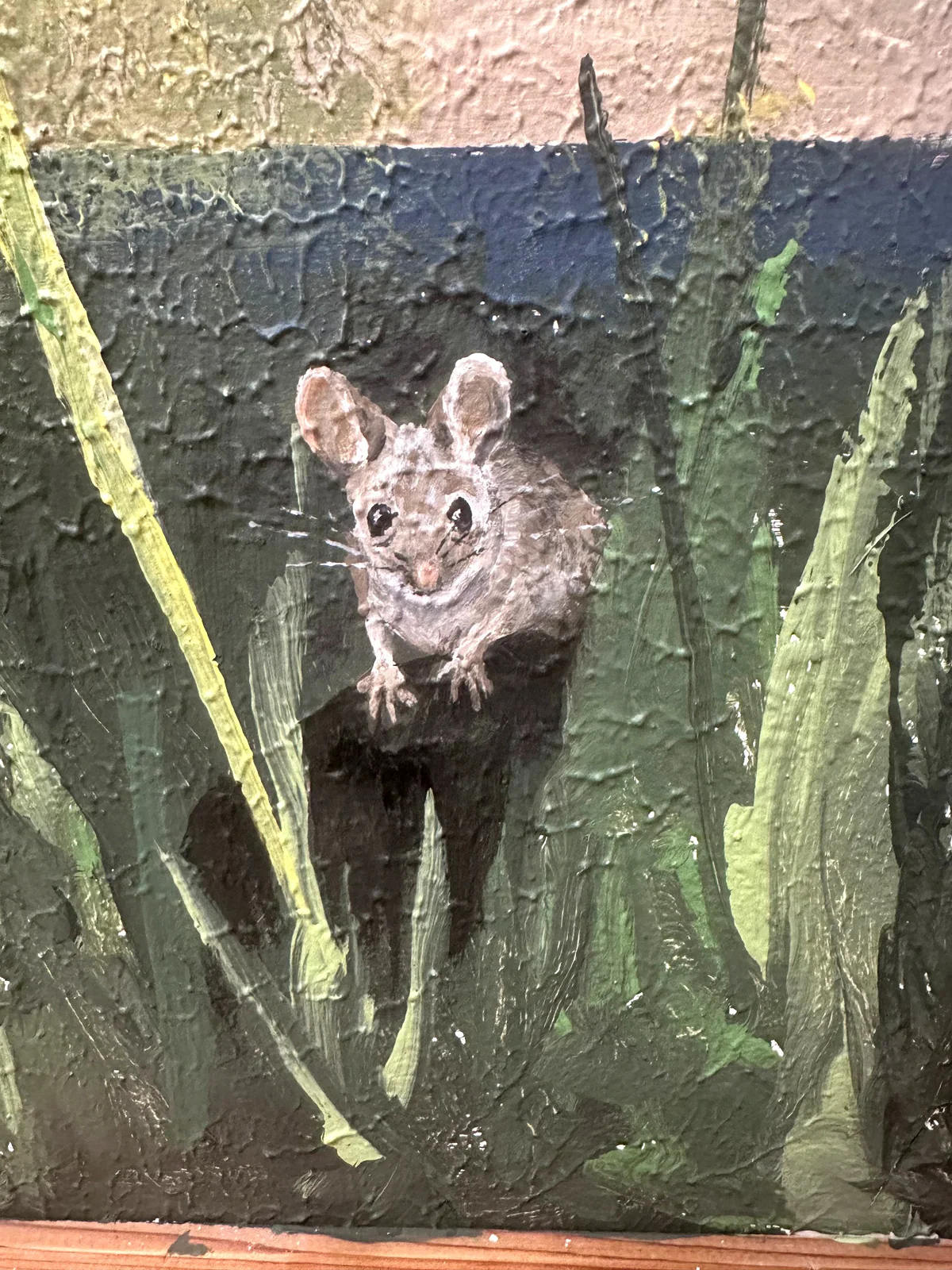 Small painted field mouse hidden among dark green grasses